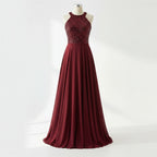 Woman wearing a burgundy evening gown with a sequined top in a store setting.