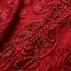Close-up of red embroidered fabric with intricate patterns and beads