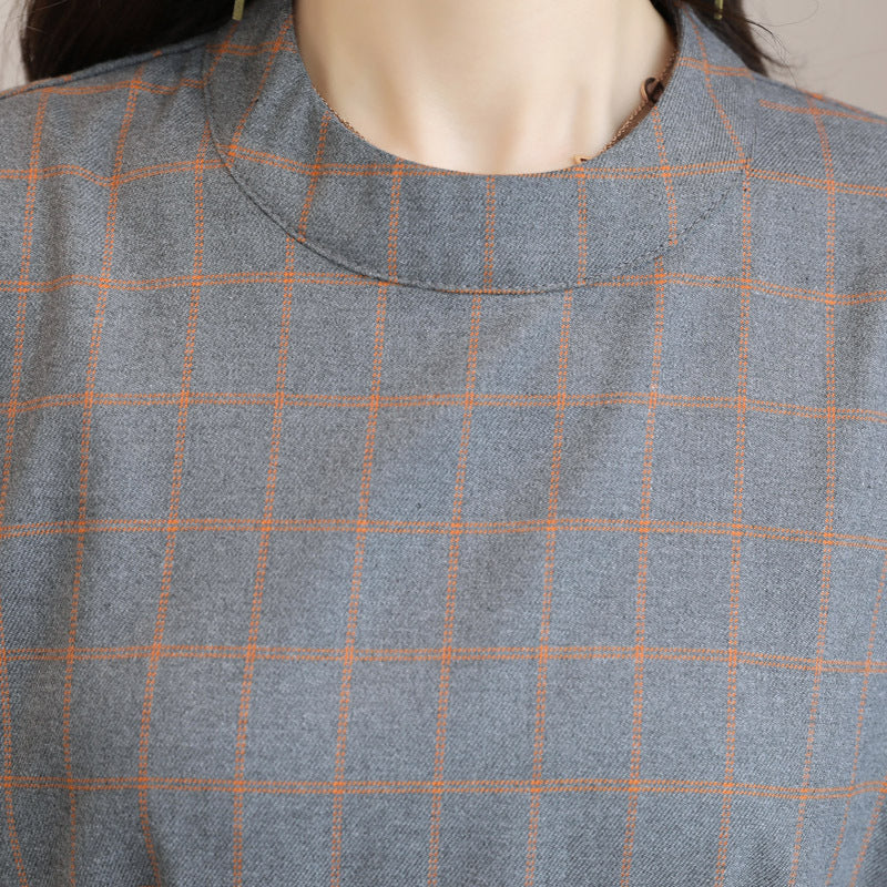 Close-up of a gray and orange checkered fabric on a mannequin