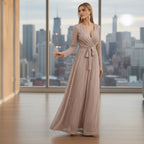 Woman wearing a long, flowing dress in a room with white walls and a small table.