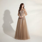 Woman wearing a glamorous evening gown with intricate detailing against a dark background