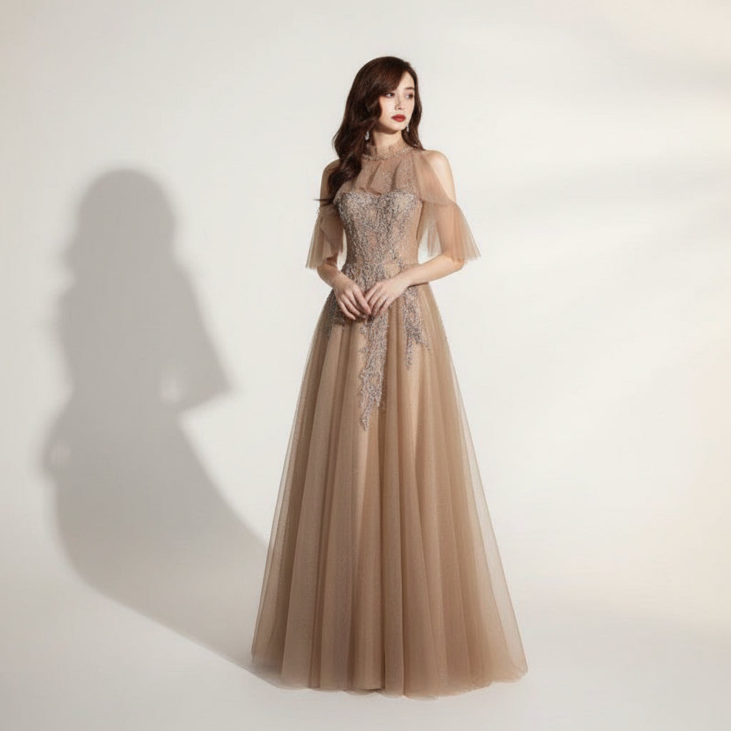 Woman wearing a glamorous evening gown with intricate detailing against a dark background