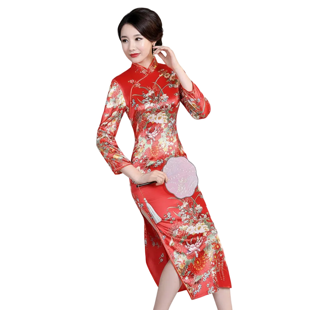 Woman in a red floral dress sitting at a wooden table with tea sets.