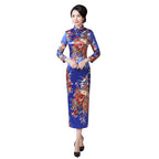 Woman in a traditional floral dress standing in a room with wooden furniture and decor.