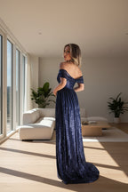 Woman in a blue evening gown standing in front of an ornate building with domes.