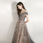 Woman wearing a glamorous evening gown with floral embellishments on a plain background