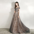 Woman wearing a gray evening gown with intricate detailing on a white background