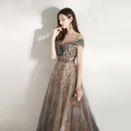 Woman in a glamorous evening gown with sequin details against a plain background