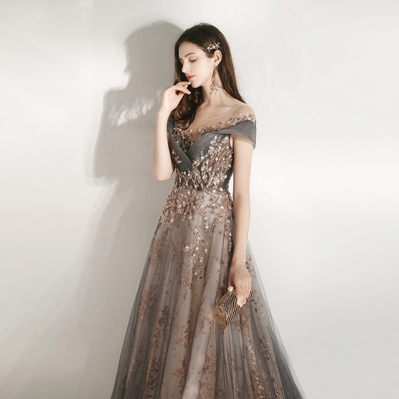 Woman in a glamorous evening gown with sequin details against a plain background