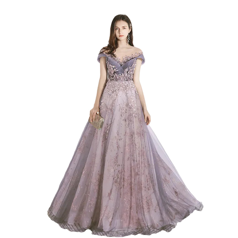 Woman wearing a purple evening gown with floral details on a white background