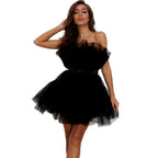 Woman wearing a black one-shoulder dress against a white background