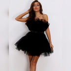Woman wearing a black one-shoulder dress against a white background