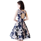 Woman wearing a floral dress with cut-out back design.
