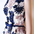Dress with blue and pink floral embroidery on a white background